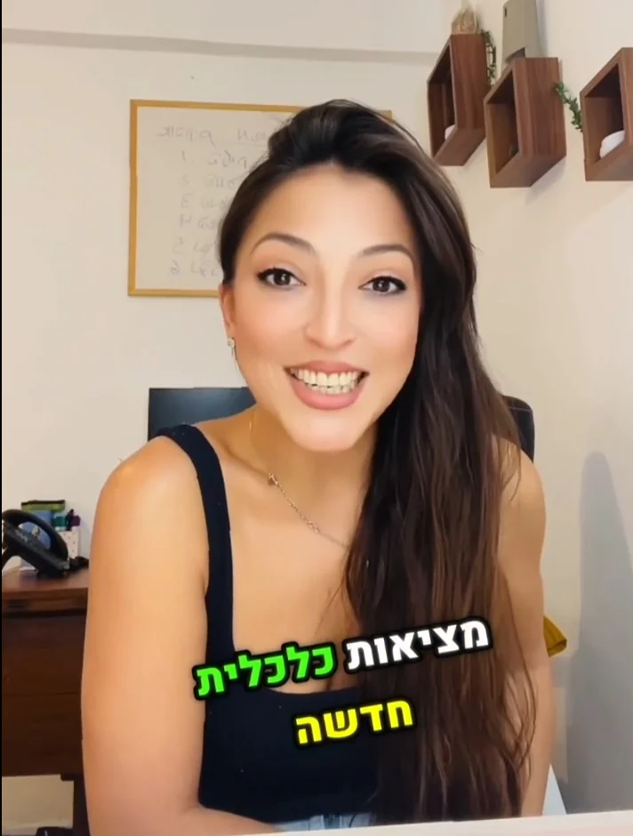 בל קסטרו מחייכת מציגה תוכן על מציאות כלכלית חדשה, עם טקסט על המסך.